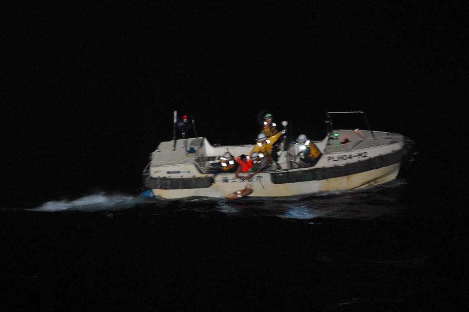 In this photo released by the 10th Regional Japan Coast Guard Headquarters, a Filipino crewmember, red jacket, of a Panamanian cargo ship is rescued by Japanese Coast Guard members in the waters off the Amami Oshima, Japan Wednesday, Sept. 2, 2020. Japanese rescuers have safely plucked the crewmember from the sea while searching for the cargo ship carrying more than 40 crew and thousands of cows went missing after sending a distress call off the southern Japanese island. (The 10th Regional Japan Coast Guard Headquarters via AP)