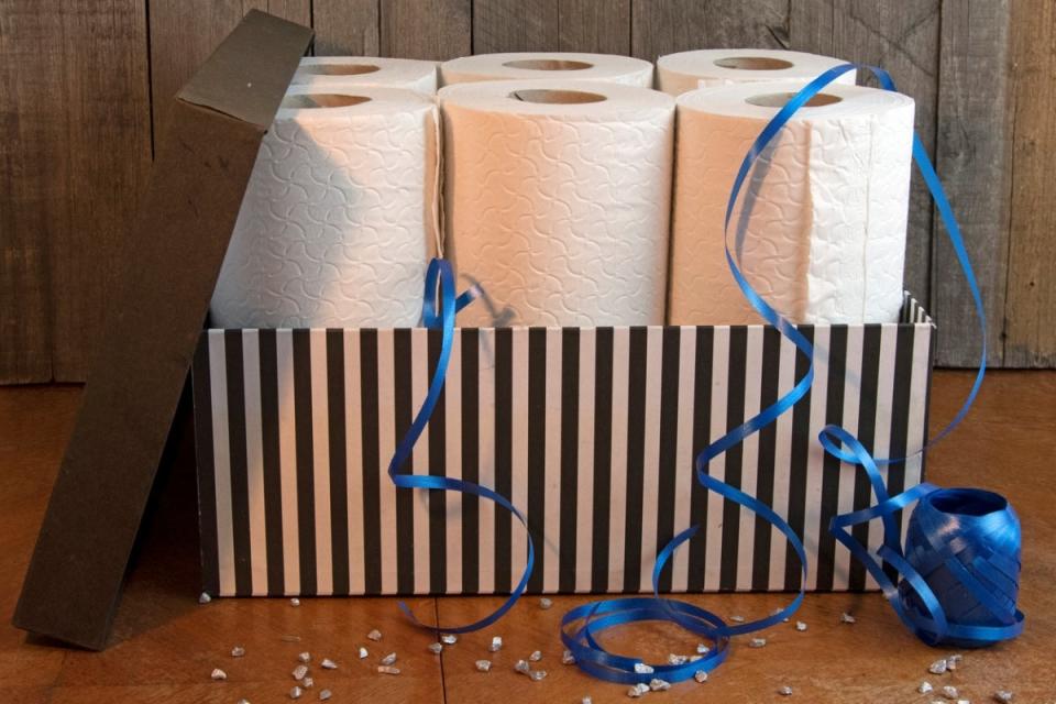 Toilet paper in a black and white-striped gift box with blue ribbon