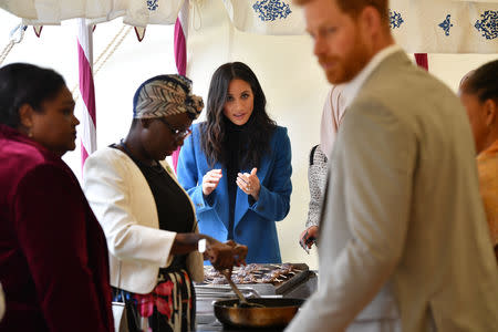 Meghan, Duchess of Sussex helps to prepare food at an event to mark the launch of a cookbook with recipes from a group of women affected by the Grenfell Tower fire at Kensington Palace in London, Britain September 20, 2018. Ben Stansall/Pool via Reuters