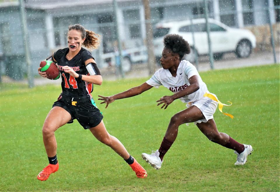 Lincoln Park Academy quarterback Leah Murphy is chased by Fort Pierce Westwood rusher Jamaya Floyd during the District 11-1A flag football championship game on Thursday, April 20, 2023 in Fort Pierce. The Greyhounds won the game 7-6.