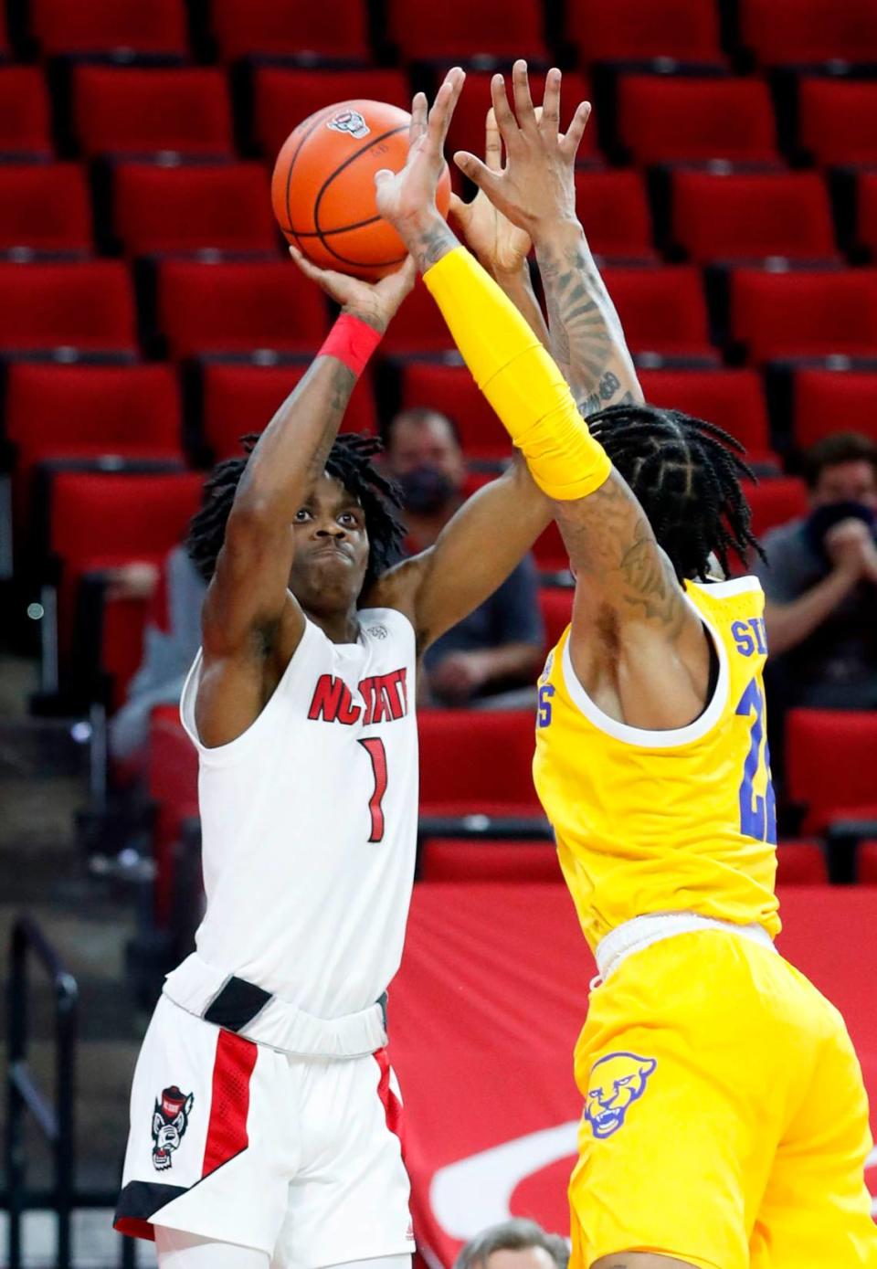 N.C. State’s Dereon Seabron (1) shoots as Pittsburgh’s Nike Sibande (22) defends during the first half of N.C. State’s game against Pittsburgh at PNC Arena in Raleigh, N.C., Sunday, February 28, 2021.