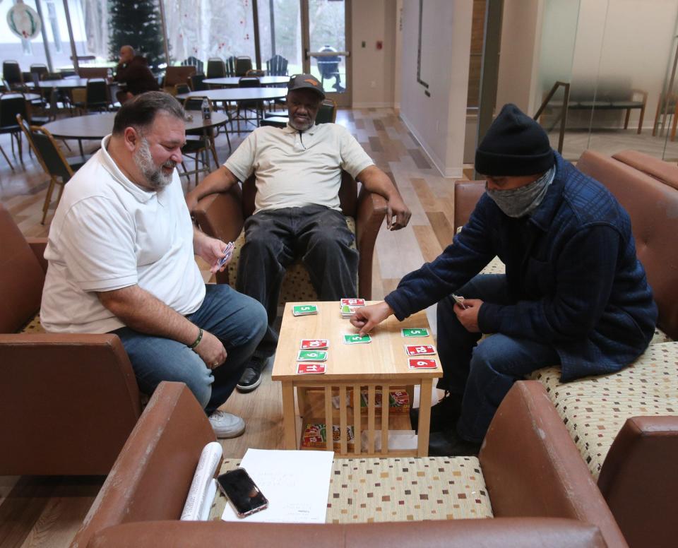 George Gonis, left, Michael Howard, center, and Damian Kyser play the card game Skip-Bo last week at Restore Addiction Recovery in Lakemore.