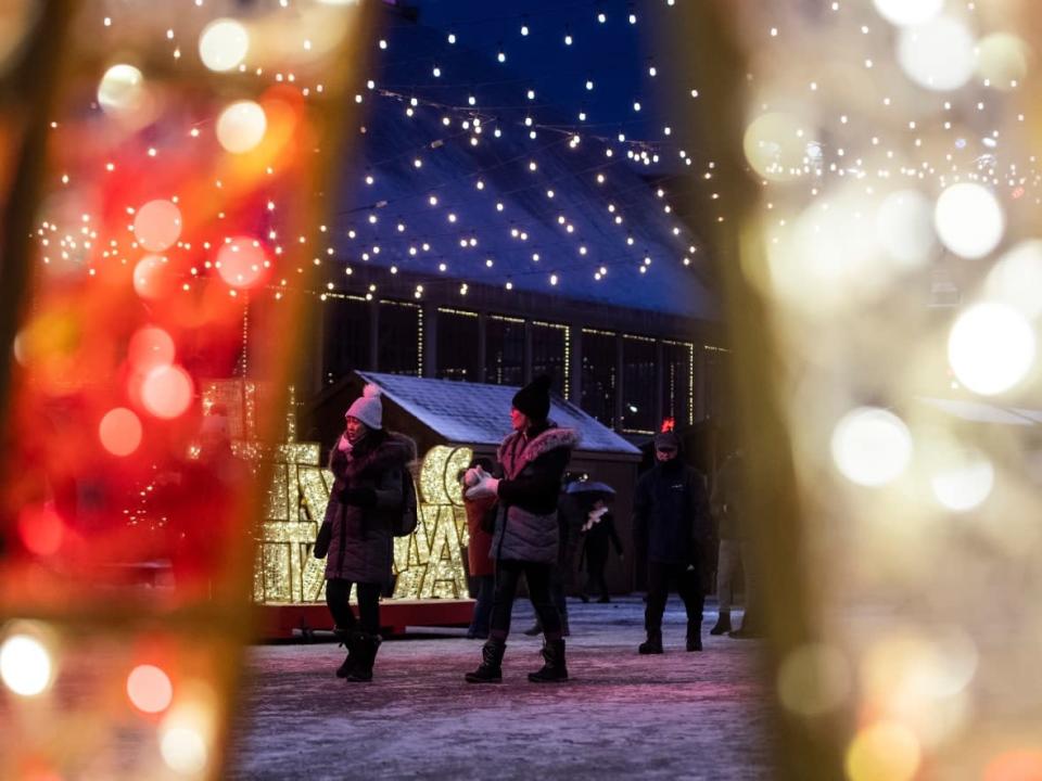 People walk among a display of holiday lights at Lansdowne Park in Ottawa, on Christmas Day, Saturday, Dec. 25, 2021. (Justin Tang/Canadian Press - image credit)