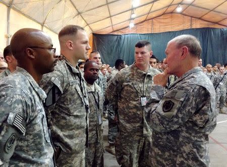 General Martin Dempsey (R), chairman of the Joint Chiefs of Staff, speaks to U.S. troops at Baghdad International Airport in Iraq November 15, 2014. REUTERS/Phil Stewart