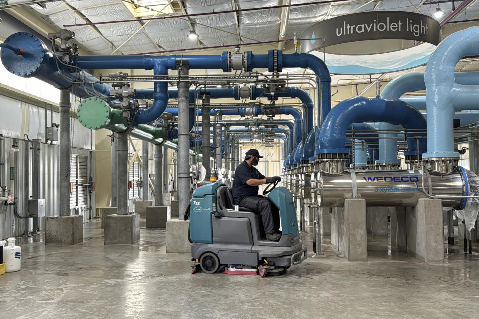 A worker cleans an ultraviolet light disinfection system as part of a water purification process at the Silicon Valley Advance Purification Center, Wednesday, Dec. 13, 2023, in San Jose, Calif. California regulators are set to vote on new rules Tuesday, Dec. 19, to let water agencies recycle wastewater and put it right back into the pipes that carry drinking water to homes, schools and businesses. (AP Photo/Terry Chea)