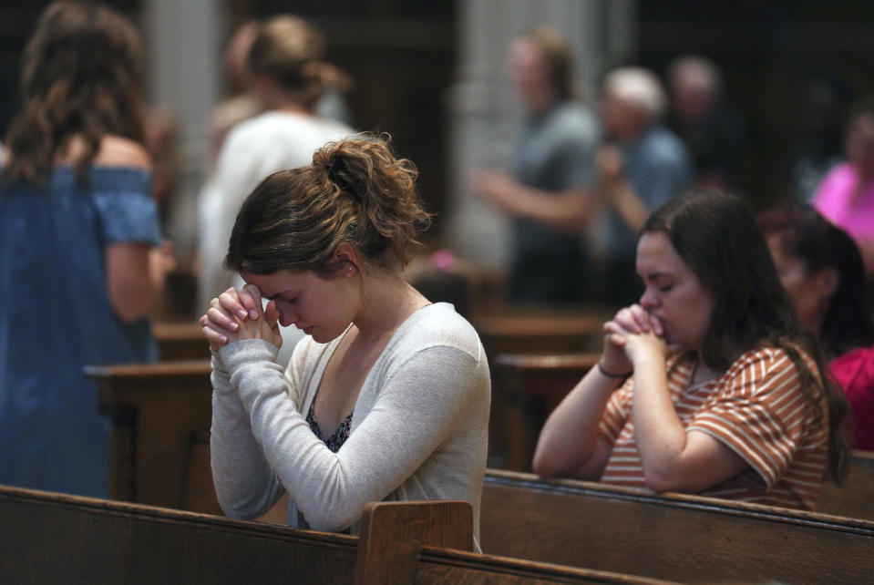 University of Pittsburgh student Olivia Meholic, front, prays after receiving Communion at St. Paul Catholic Cathedral in Pittsburgh on Sunday, June 26, 2022. During the service, the Very Rev. Kris Stubna gave a homily focused on the Supreme Court's decision to overturn the nearly 50-year-old Roe v. Wade ruling, which he said was the result of prayers and efforts of many Catholics and others. (AP Photo/Jessie Wardarski)
