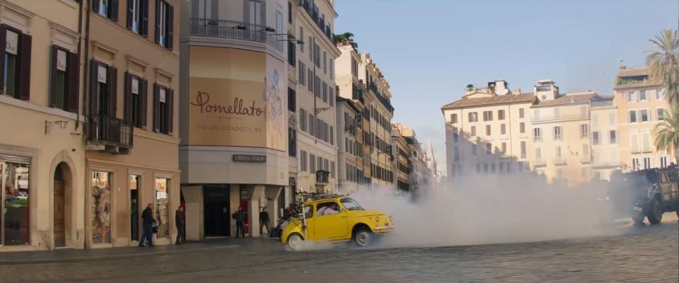 yellow fiat 500 drifts around rome