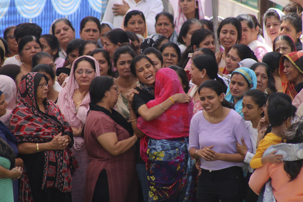 People wail as they watch rescuers work at the site of a structure built over an old temple well that collapsed Thursday when a large crowd of devotees gathered for the Ram Navami Hindu festival, in Indore, India, Friday, March 31, 2023. Thirty-five bodies have been found inside a well at a Hindu temple in central India after dozens of people fell into the muddy water when the well's cover collapsed. (AP Photo)