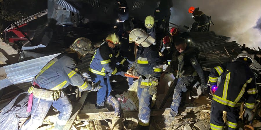 Rescuers carry a person freed from the rubble of a residential building destroyed by a Russian missile strike in Kharkiv