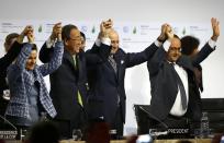 FILE - French President Francois Hollande, right, French Foreign Minister and president of the COP21 Laurent Fabius, second right, United Nations climate chief Christiana Figueres, left, and United Nations Secretary General Ban Ki-moon hold their hands up in celebration after the final conference at the COP21, the United Nations conference on climate change, in Le Bourget, north of Paris on Dec. 12, 2015. (AP Photo/Francois Mori, File)