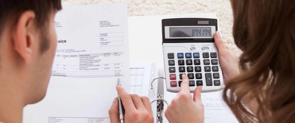 Portrait of young happy couple calculating budget