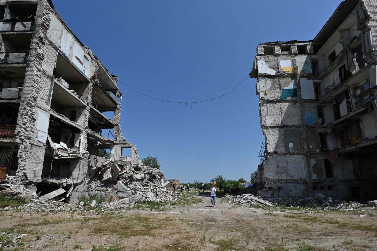 A man walks among destroyed buildings in Izyum, Kharkiv region (AFP via Getty Images)