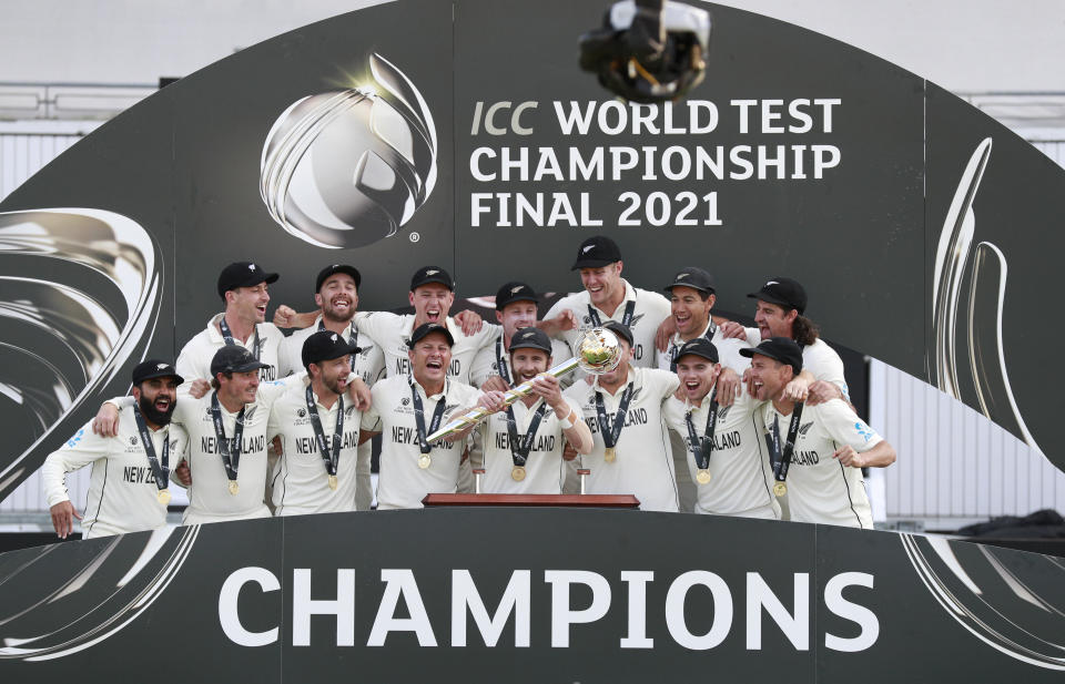 New Zealand players celebrate with the winners trophy after their win in the World Test Championship final cricket match against India, at the Rose Bowl in Southampton, England, Wednesday, June 23, 2021. New Zealand won the match by eight wickets. (AP Photo/Ian Walton)