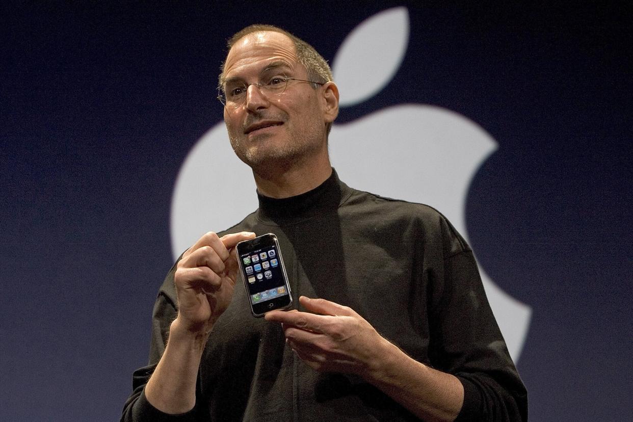 Apple CEO Steve Jobs holds up the new iPhone that was introduced at Macworld on January 9, 2007 in San Francisco, California. The new iPhone will combine a mobile phone, a widescreen iPod with touch controls and a internet communications device with the ability to use email, web browsing, maps and searching. The iPhone will start shipping in the US in June 2007.