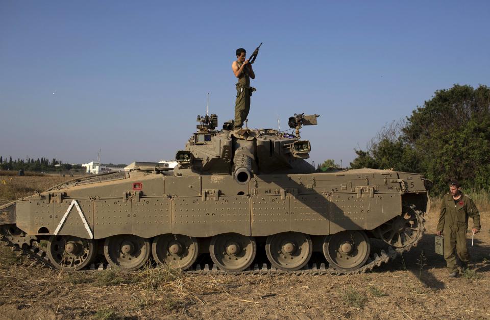 An Israeli soldier checks his weapon atop a tank near the border with Gaza July 27, 2014. The Israeli military started fighting again in the Gaza Strip on Sunday, saying Hamas militants had ignored a 24-hour, humanitarian ceasefire requested by the United Nations. Residents in Gaza reported hearing heavy shelling east of Gaza City shortly after the announcement was made. REUTERS/Siegfried Modola (ISRAEL - Tags: CIVIL UNREST MILITARY CONFLICT POLITICS TPX IMAGES OF THE DAY)