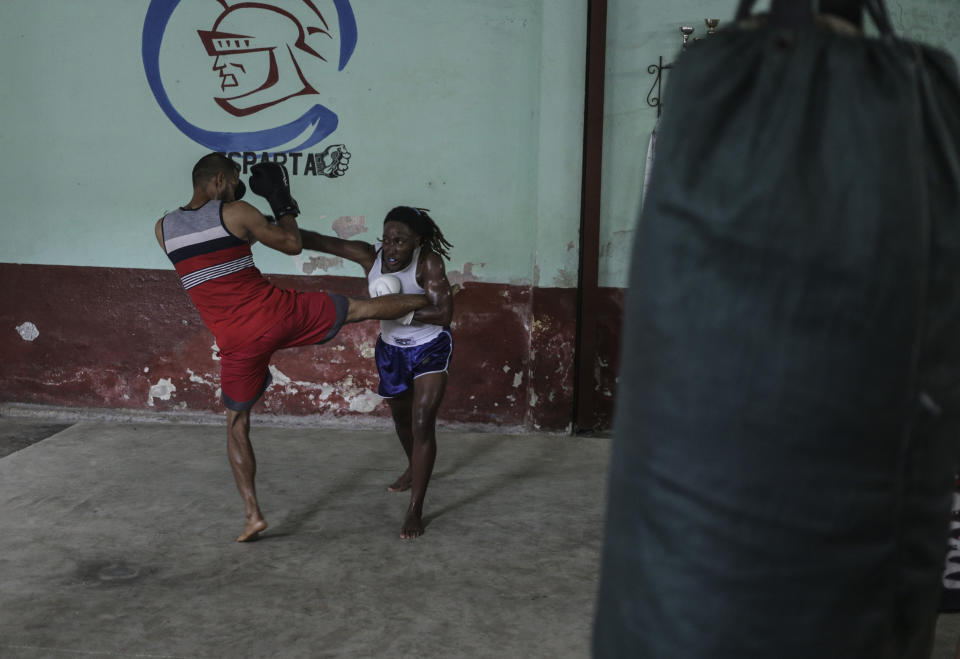 Transgender Cuban athlete Ely Malik Reyes, right, who practices mixed martial arts known as sanda, spars with fellow athlete Leandro Matos at a gym in Regla, across the bay from Havana, Cuba, Tuesday, June 11, 2024. Reyes became the first trans athlete to officially compete in a Cuban league. (AP Photo/Ariel Ley)