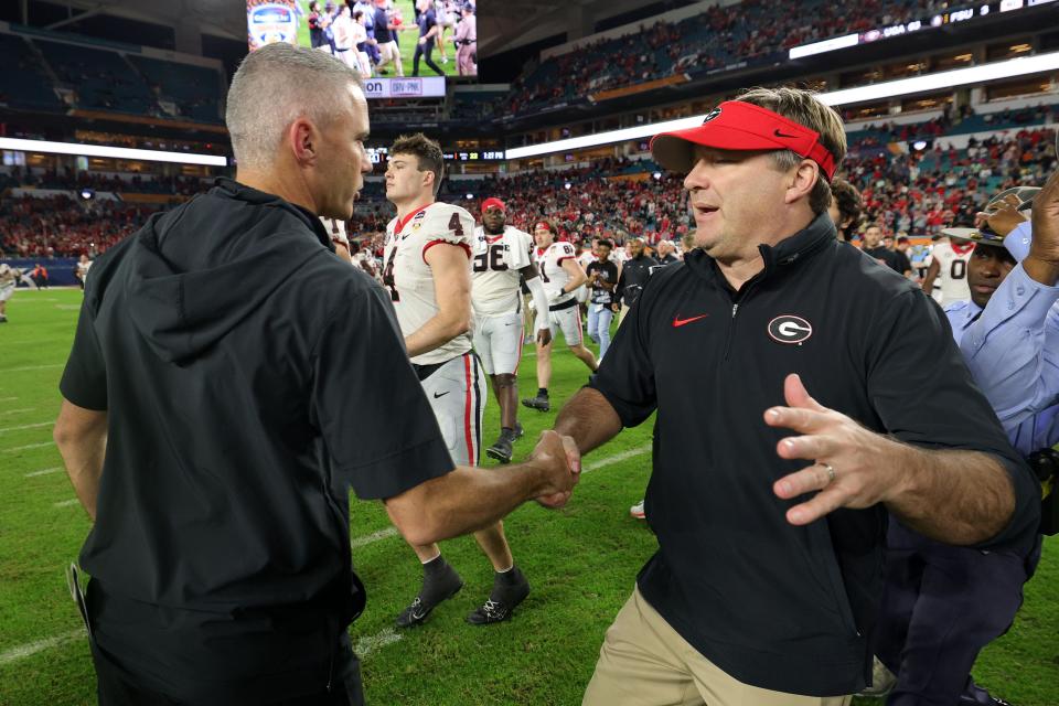 Georgia Bulldogs head coach Kirby Smart (right) shakes hands with Florida State Seminoles head coach Mike Norvell (left) after the 2023 Orange Bowl at Hard Rock Stadium.