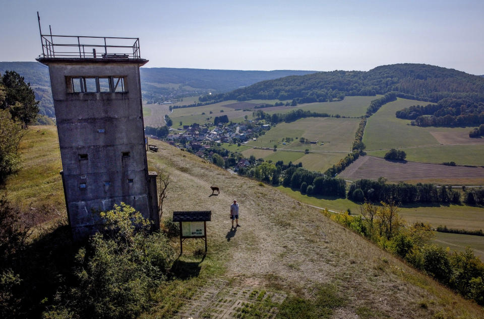 A former East German watch tower stands on a hill high above the former border area between East and West Germany in Unterweid, eastern Germany, Monday, Sept. 21, 2020. Thirty years after Germany was reunited on Oct. 3, 1990, many once-decrepit city centers in the formerly communist east have been painstakingly restored and new factories have sprung up. But many companies and facilities didn't survive the abrupt transition to capitalism inefficient companies found themselves struggling to compete in a market economy, while demand for eastern products slumped and outdated facilities were shut down. (AP Photo/Michael Probst)