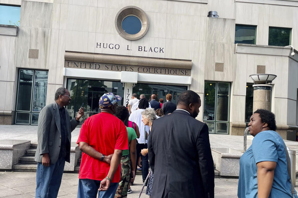 A line of people wait outside the federal courthouse in Birmingham, Ala., on Monday, Aug. 14, 2023. to watch the Aug. 14, 2023 hearing. A three-judge panel is reviewing Alabama's new congressional districts. They will decide whether to let the map stand or step in and draw districts for the state. (AP Photo/Kim Chandler)