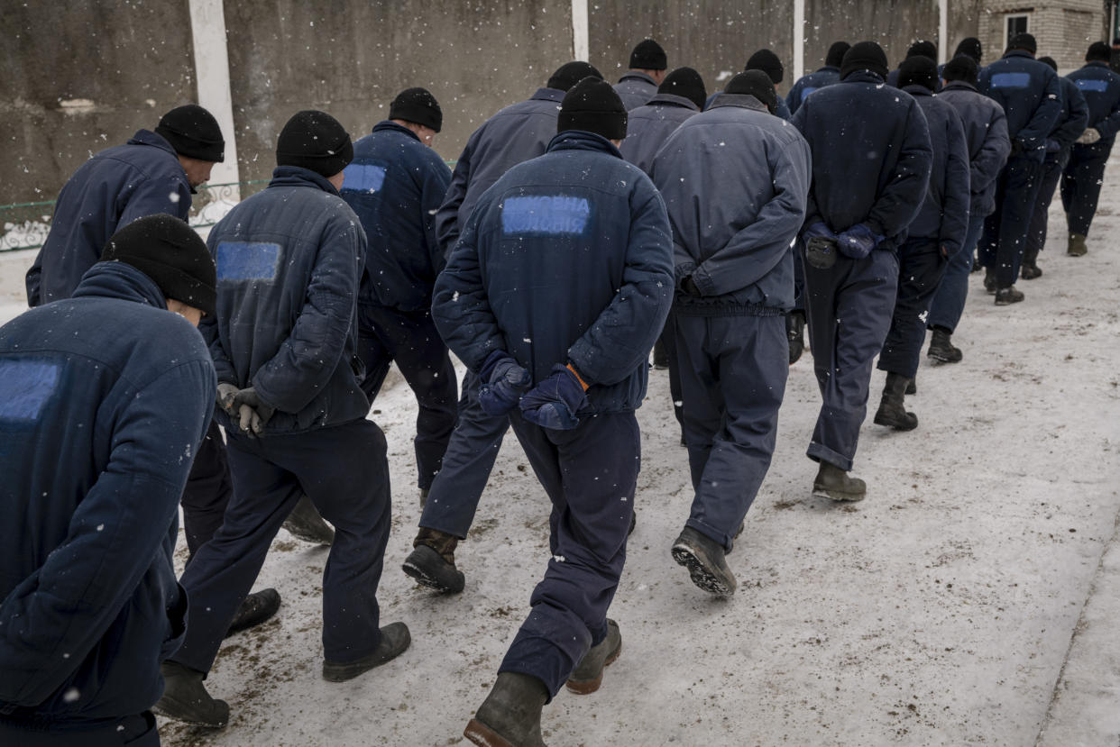 Prisioneros de guerra rusos son escoltados por el director del campo de prisioneros en el oeste de Ucrania, el 6 de febrero de 2023. (Nicole Tung/The New York Times)