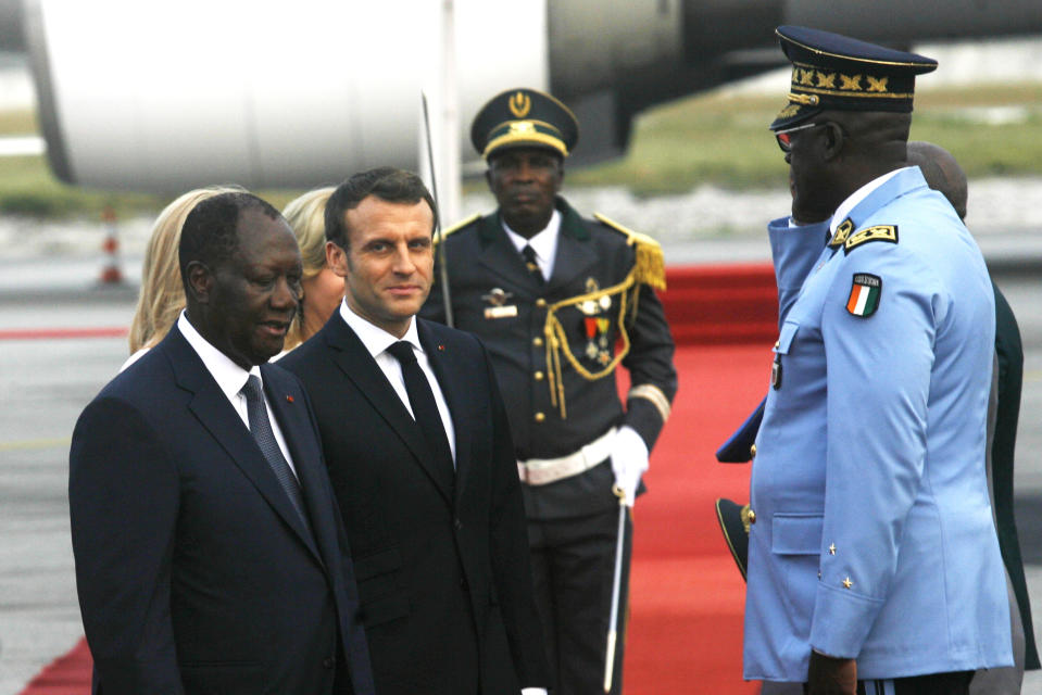 French President Emmanuel Macron is welcomed by President Alassane Ouattara upon arrival in Abidjan, Ivory Coast, Friday Dec. 20, 2019. Macron is in Ivory Coast for a three-day official visit. (AP Photo/Diomande Ble Blonde)