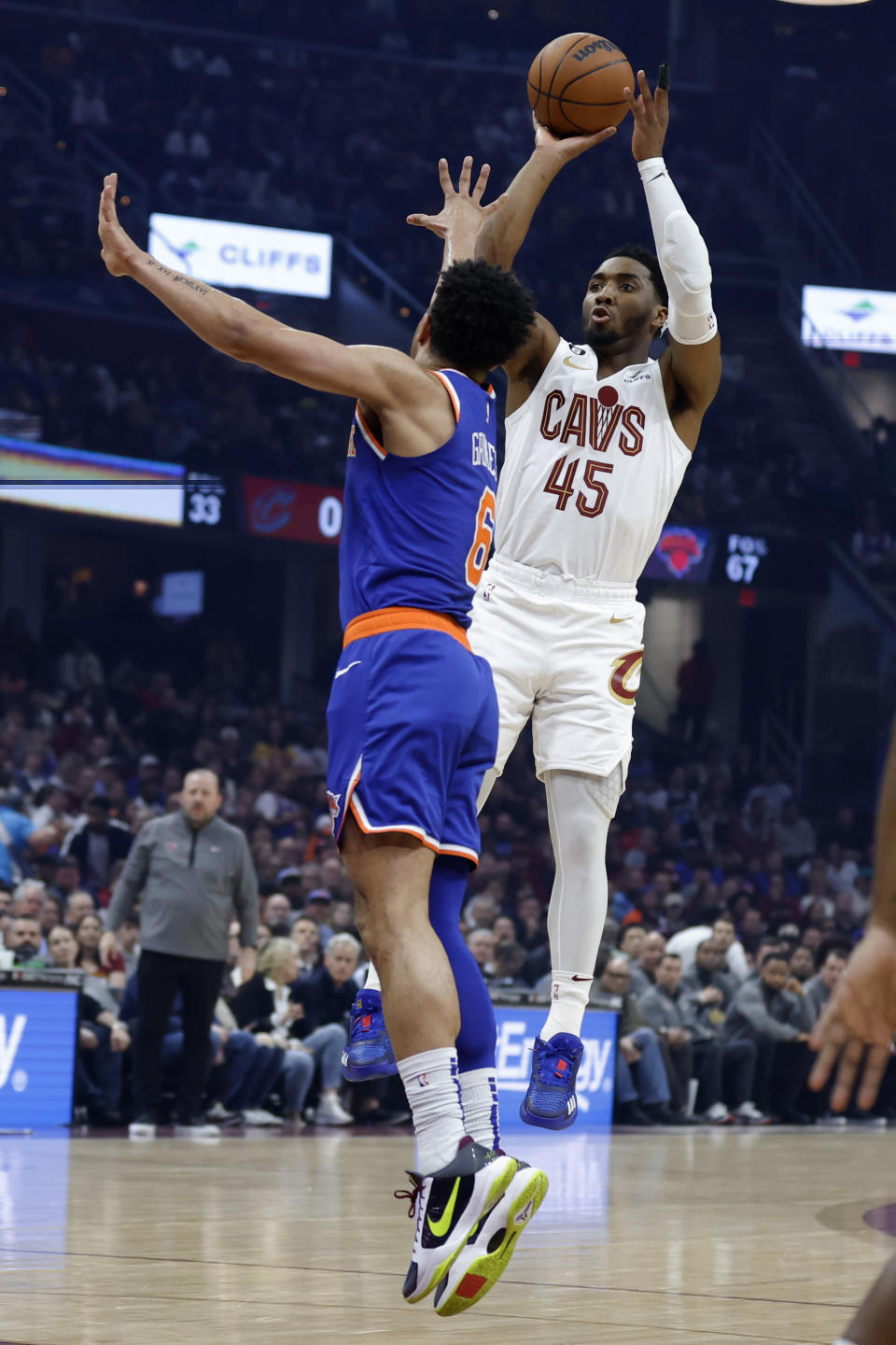 Cleveland Cavaliers guard Donovan Mitchell (45) shoots against New York Knicks guard Quentin Grimes (6) during the first half of an NBA basketball game Friday, March 31, 2023, in Cleveland. (AP Photo/Ron Schwane)