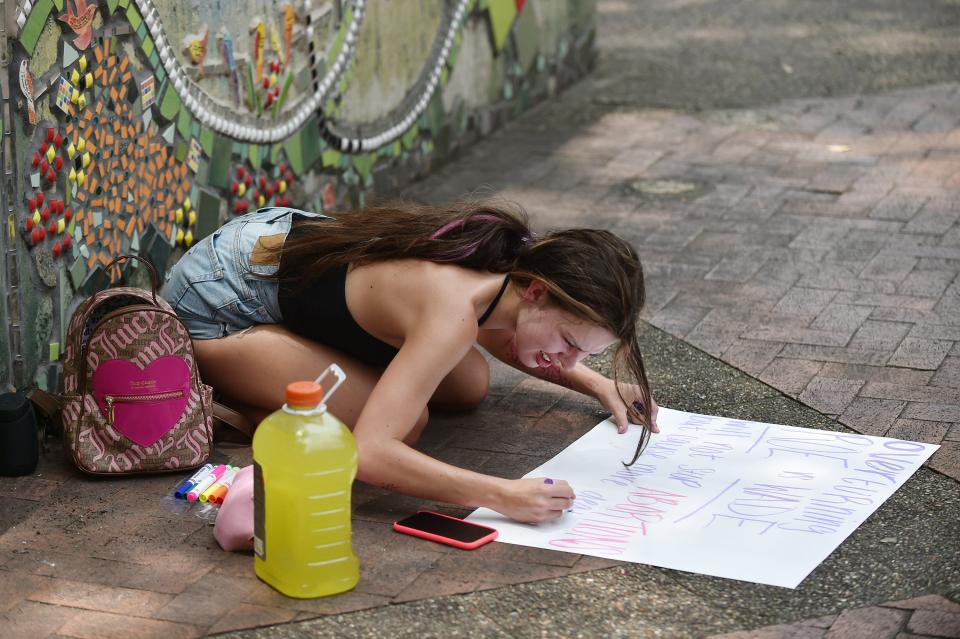 Shyanne Padgett, 20 works on her handmade sign in James Weldon Johnson Park in reaction to the overturning of Roe vs Wade by the Supreme Court Friday.