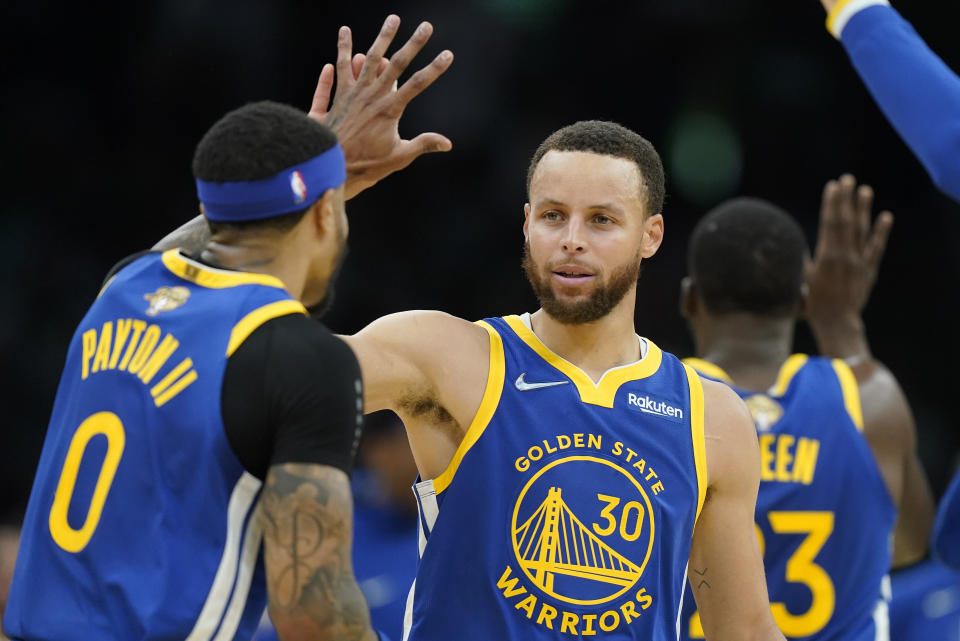 Golden State Warriors guard Stephen Curry (30) high fives Golden State Warriors guard Gary Payton II (0) during the second quarter of Game 6 of basketball's NBA Finals against the Boston Celtics, Thursday, June 16, 2022, in Boston. (AP Photo/Steven Senne)