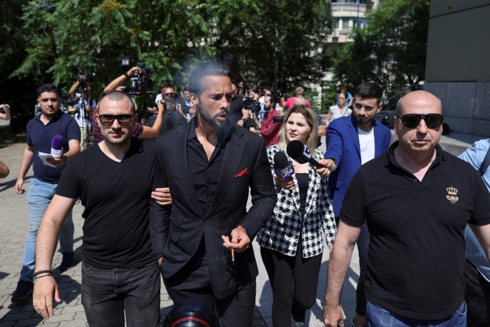 Tristan Tate, escorted by bodyguards, arrives at court in Bucharest (Inquam Photos/Sabin Cirstoveanu)