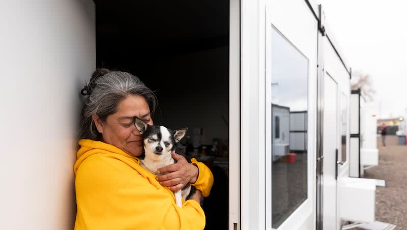 Jacqui Hatch poses with her dog Zoe outside her unit at the Switchpoint microshelter community in Salt Lake City on Thursday, March 21, 2024. “I’ve been here for a couple of weeks on a domestic violence case,” she says. “It’s been really difficult.”