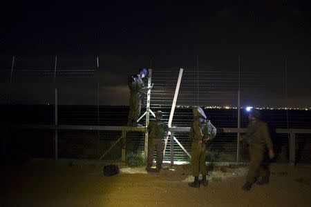 Israeli soldiers repair a malfunction in Israel's border fence with southern Gaza July 8, 2015. REUTERS/Ronen Zvulun