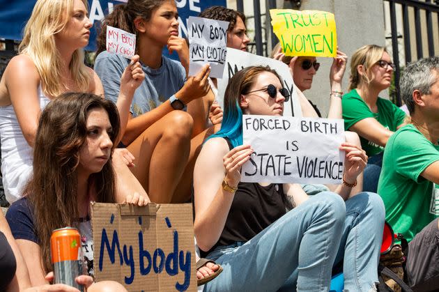 Demonstrators hold signs during a rally at the Massachusetts State House in Boston. (Photo: JOSEPH PREZIOSO via Getty Images)