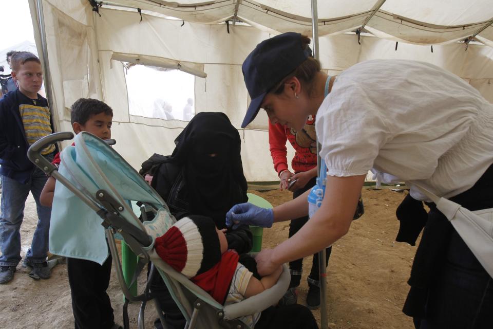 A child receives a polio vaccine at a Syrian refugee camp in the Bekaa Valley