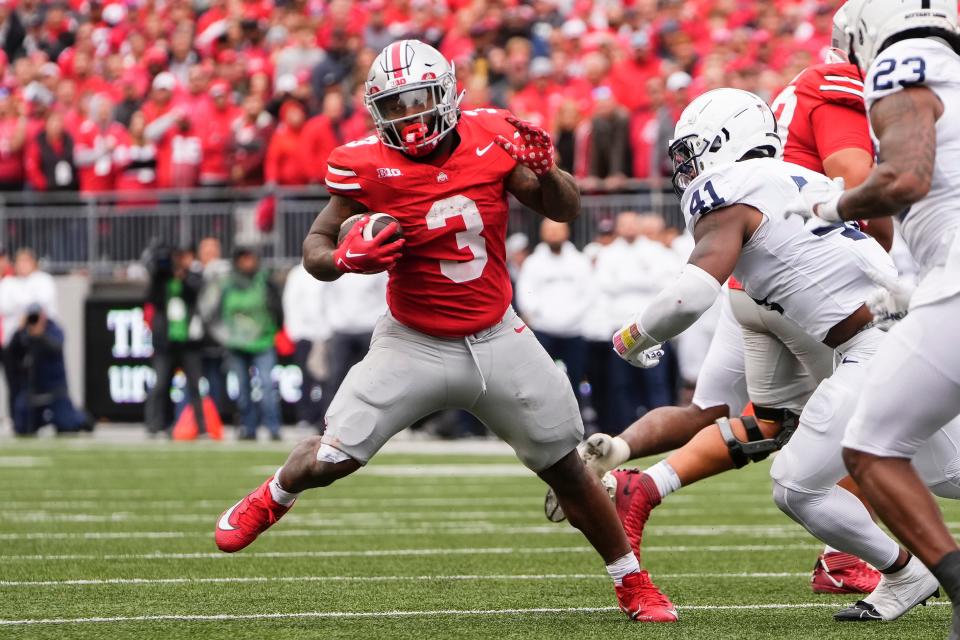 Oct 21, 2023; Columbus, Ohio, USA; Ohio State Buckeyes running back Miyan Williams (3) runs around Penn State Nittany Lions linebacker Kobe King (41) during the NCAA football game at Ohio Stadium.