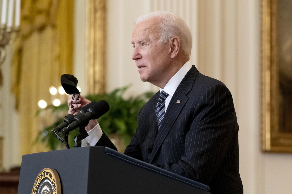 President Joe Biden holds his face mask as he speaks about COVID-19 vaccinations in the East Room of the White House, Thursday, March 18, 2021, in Washington. (AP Photo/Andrew Harnik)