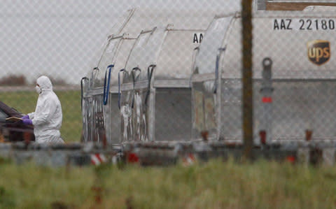 A forensic officer removes a package from a UPS container at East Midlands Airport in Castle Donington - Credit: REUTERS/Darren Staples