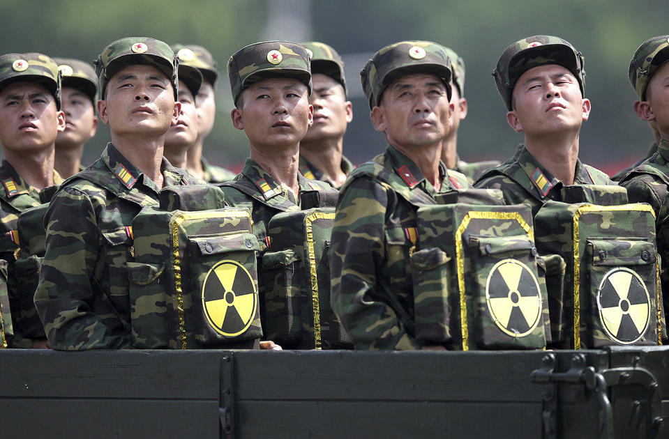 <p>North Korean soldiers turn and look towards their leader Kim Jong Un from a military parade vehicle as they carry packs marked with the nuclear symbol during a ceremony marking the 60th anniversary of the Korean War armistice in Pyongyang, North Korea, July 27, 2013. (Wong Maye-E/AP) </p>