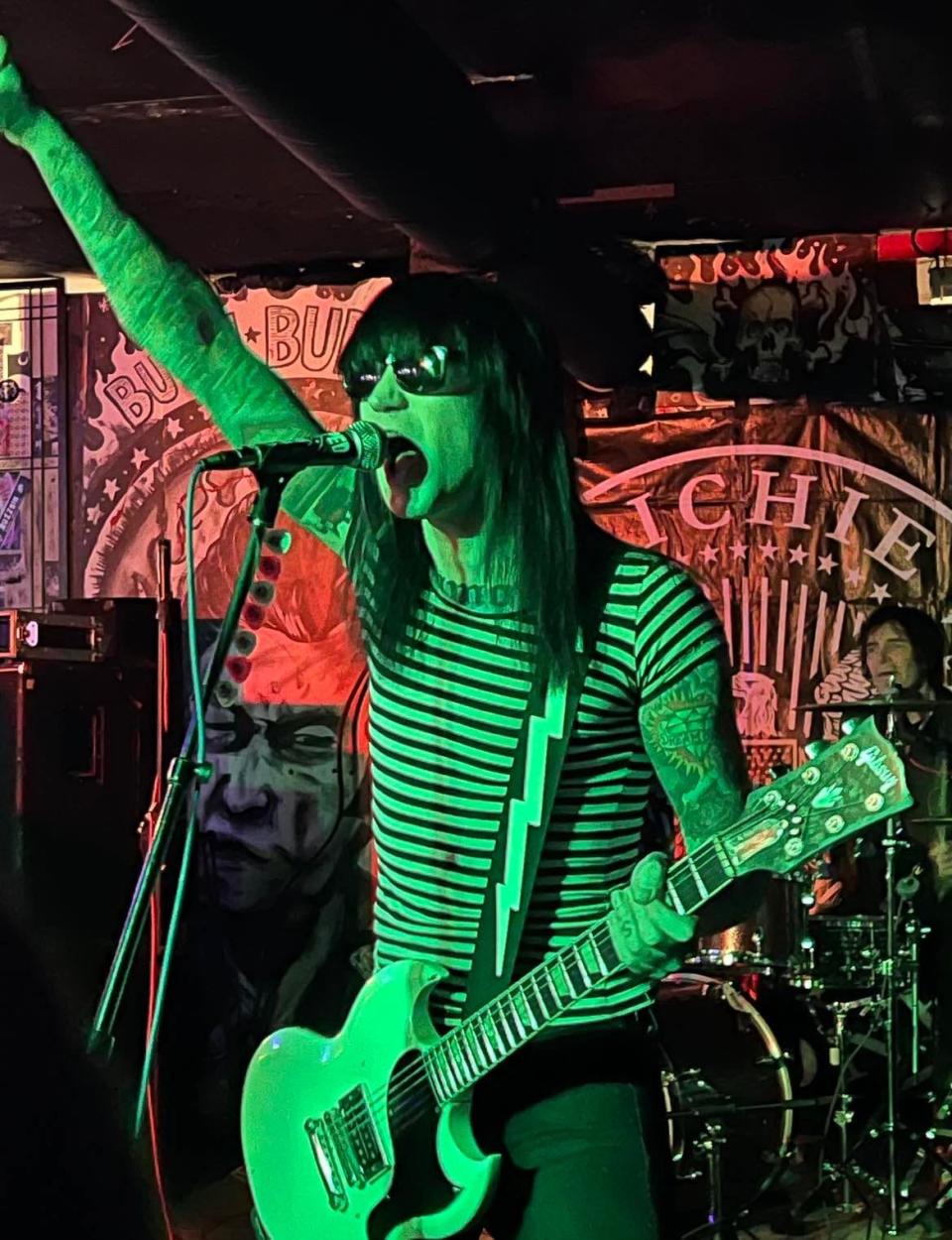 The guitarist for Richie Ramone's band raises his fist in the air during a concert in April at Buzzbin in downtown Canton. Buzzbin closed last summer and has relocated in Kenmore in Akron.