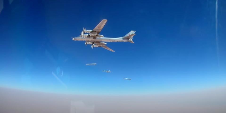 A Russian plane drops AS-23A Kodiak missiles against a blue sky