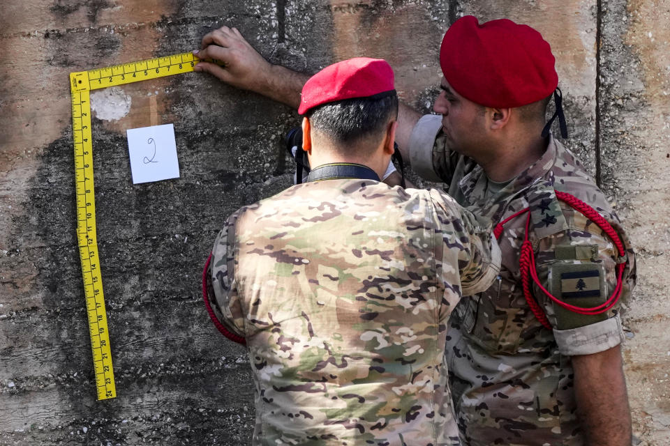 Lebanese Army investigators inspect bullet holes and collect forensic evidence next to the entrance of U.S. Embassy in Aukar, a northern suburb of Beirut, Lebanon, Thursday, Sept. 21, 2023. Lebanon's security agencies have launched an investigation into a late night shooting outside the U.S. embassy in Lebanon that caused no injuries, officials said Thursday. (AP Photo/Hassan Ammar)