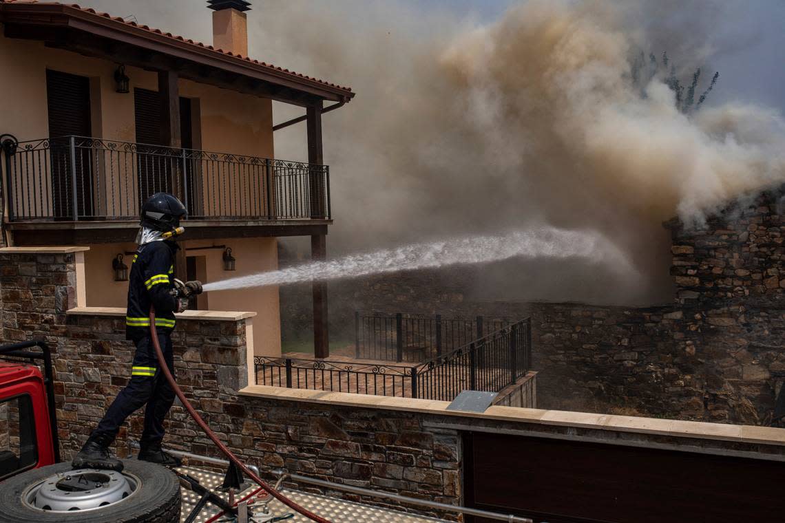 A firefighter tries to extinguish flames as wildfire advance during a wildfire in Ferreras de Abajo in north western Spain, Monday, July 18, 2022. Firefighters battled wildfires raging out of control in Spain and France as Europe wilted under an unusually extreme heat wave that authorities in Madrid blamed for hundreds of deaths. (AP Photo/Emilio Fraile)