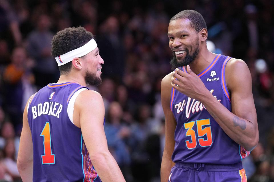 Phoenix Suns guard Devin Booker (1) and Phoenix Suns forward Kevin Durant (35) look on against the Portland Trail Blazers during the second half at Footprint Center in Phoenix on Nov. 21, 2023.