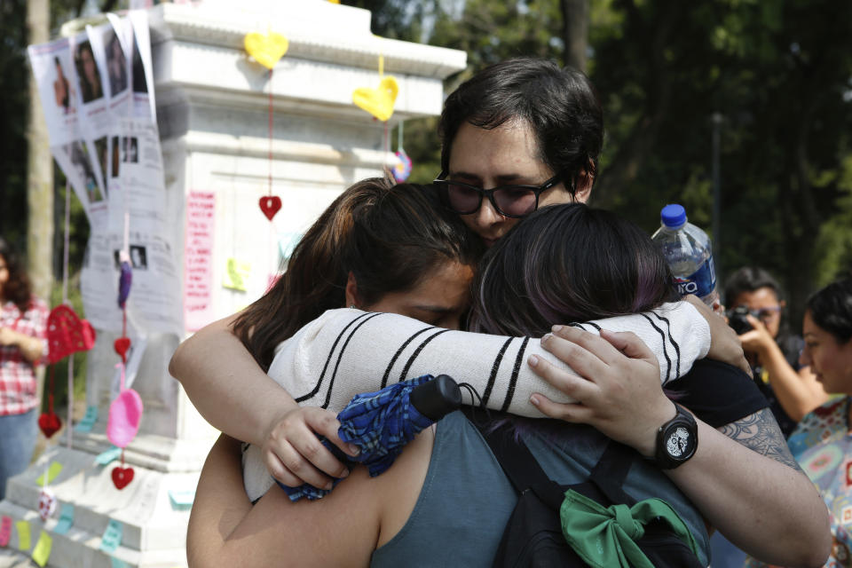 Women hug during a tribute for murdered women, in the Alameda park of Mexico City, Saturday, Aug. 24, 2019. A small group of women constructed a memorial made of hand-knit hearts. The knit-in on came on the heels of rowdy protests sparked by outrage over bungled investigations into alleged rapes of teenagers by local policemen. (AP Photo/Ginnette Riquelme)