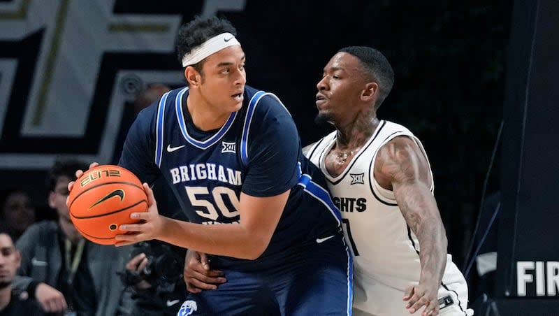 BYU center Aly Khalifa (50) looks for a way around Central Florida forward C.J. Walker, right, during the first half of an NCAA college basketball game, Saturday, Jan. 13, 2024, in Orlando, Fla.