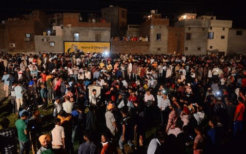 Indian relatives and revellers gather around the bodies of the victims of a train accident during the occasion of the Hindu festival of Dussehra in Amritsar  - Credit: NARINDER NANU/AFP