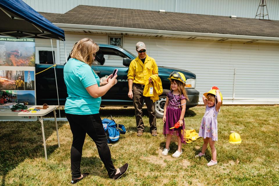 Silver Incarnato, left, photographs her daughters, Stella, (middle) 6, and Tilly, 3, as Ryan Zeisler looks on, Saturday, June 10 during  the fourth annual HRN Firefighter Field Day. Zeisler is a firefighter with the Northeast Ohio Fire Force Group, which is a part of the Ohio Division of Forestry's Division of Natural Resources. Proceeds from the event went to benefit the Akron Children’s Hospital Burn Camp program.