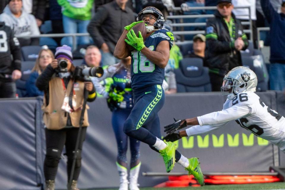 Seattle Seahawks wide receiver Tyler Lockett (16) catches a touchdown pass from quarterback Geno Smith (7) as Las Vegas Raiders cornerback Rock Ya-Sin (26) defends during the second quarter of an NFL game on Sunday, Nov. 27, 2022, at Lumen Field in Seattle.