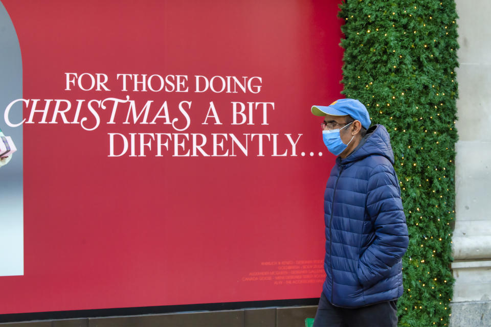 A man walks past a Christmas poster with the words “For those doing Christmas a bit different” outside the Selfridges store in London’s Oxford Street on the eve of the second lockdown in London. (Photo by Dave Rushen / SOPA Images/Sipa USA)