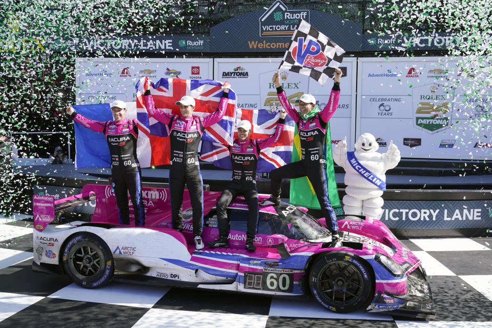 Winners of the Rolex 24 hour auto race, from left, Simon Pagenaud, of France, Oliver Jarvis, of Great Britain, Tom Blomqvist, of Monaco and Helio Castroneves, of Brazil celebrate in Victory Lane at Daytona International Speedway, Sunday, Jan. 30, 2022, in Daytona Beach, Fla. (AP Photo/John Raoux)