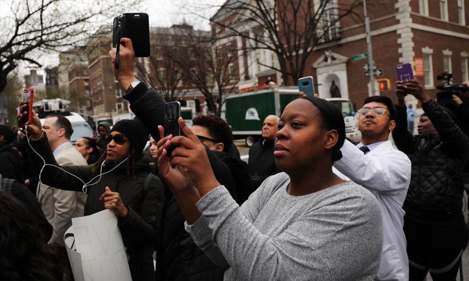 People gather to watch the removal of a statue of J Marion Sims.